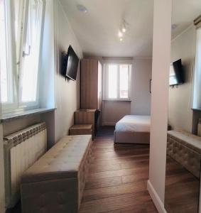Cette petite chambre comprend un lit et un canapé. dans l'établissement HH Hermoso Housing Asti, à Asti