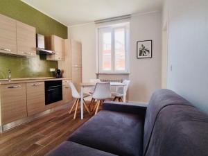 a living room with a couch and a kitchen with a table at HH Hermoso Housing Asti in Asti