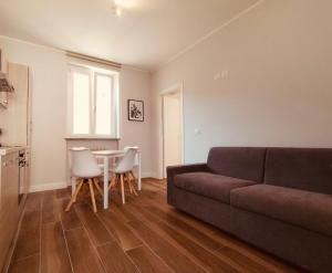 a living room with a couch and a table at HH Hermoso Housing Asti in Asti