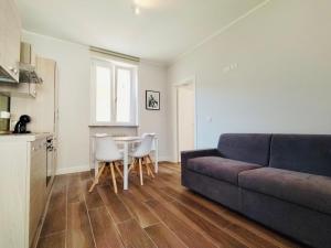 ein Wohnzimmer mit einem Sofa und einem Tisch in der Unterkunft HH Hermoso Housing Asti in Asti