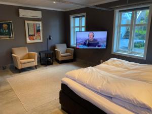 a bedroom with a bed and a flat screen tv at Suite i gjestehus, nær sentrum in Sandefjord