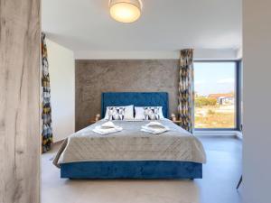 ein Schlafzimmer mit einem blauen Bett und einem großen Fenster in der Unterkunft Holiday Home Villa MI by Interhome in Pula + 46 Fotos
