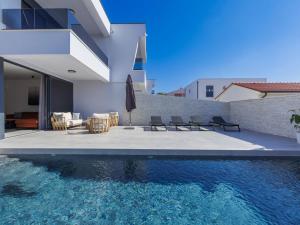 ein Swimmingpool mit Stühlen und ein Haus in der Unterkunft Holiday Home Villa MI by Interhome in Pula