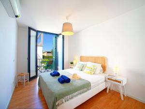 ein Schlafzimmer mit einem Bett mit blauen Handtüchern darauf in der Unterkunft Apartment Precious time by Interhome in Tavira