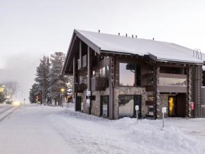 Holiday Home Levi platinum 2 b 6 by Interhome في ليفي: مبنى مغطى بالثلج في شارع ثلجي