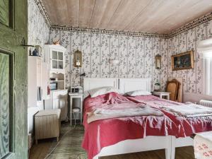 1 dormitorio con 1 cama con colcha roja en Holiday Home Karsbo gård - VML114 by Interhome, en Norberg