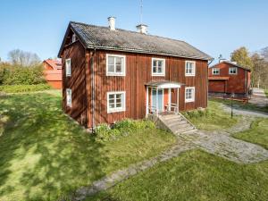 una pequeña casa de madera en un campo de hierba en Holiday Home Karsbo gård - VML114 by Interhome, en Norberg