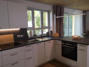 a kitchen with white cabinets and a black counter top at Ferienhaus "Am Saarbach" in Ochsenfurt