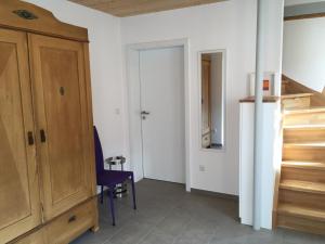 Cette chambre comprend une armoire en bois et une chaise bleue. dans l'établissement Ferienhaus "Am Saarbach", à Ochsenfurt