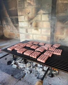 a bunch of sausages cooking on a grill at Vikendica Villa Ramona Banja Luka in Banja Luka