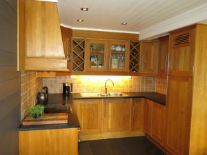 a kitchen with wooden cabinets and a sink at Holiday Home Hovden - SET086 by Interhome in Hovden