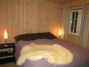 a bedroom with a bed with a white blanket on it at Holiday Home Hovden - SET086 by Interhome in Hovden
