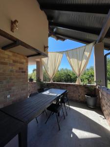an outdoor patio with a wooden table and chairs at Vikendica Villa Ramona Banja Luka in Banja Luka
