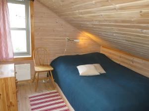 a small bedroom with a blue bed and a chair at Holiday Home Morgenro - SOW160 by Interhome in Åseral