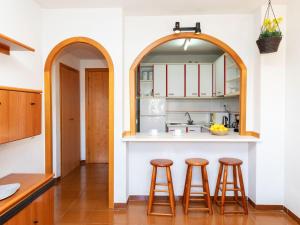 uma cozinha em plano aberto com dois bancos de bar e um balcão em Apartment Jerez-2 by Interhome em Salou