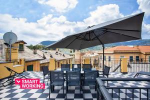 a patio with a table and chairs and an umbrella at Riviera Flavour Apartments II by Wonderful Italy in Santa Margherita Ligure