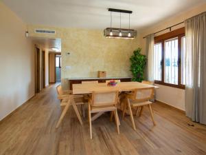 Un comedor con mesa y sillas de madera. en Villa Agave by Interhome, en Calpe