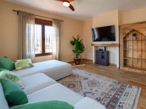 sala de estar con 2 sofás blancos y TV en Villa Agave by Interhome, en Calpe