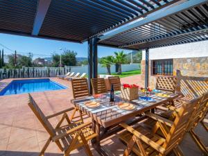 Un patio con mesa y sillas y una piscina. en Villa Agave by Interhome, en Calpe