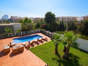 una piscina con tumbonas y palmeras en Villa Agave by Interhome, en Calpe