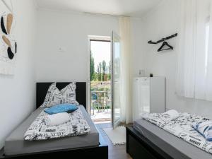 a bedroom with two beds and a balcony at Apartment Johann 2 by Interhome in Balatonszárszó +17 photos