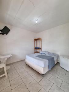 a bedroom with a bed and a tiled floor at Recanto Aconchego Itapoá in Itapoa