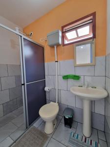 a bathroom with a toilet and a sink and a shower at Recanto Aconchego Itapoá in Itapoa