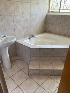 a bathroom with a tub and a sink at Good Life Guest house in Orkney +27731671754 in Orkney