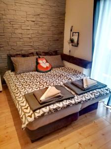 Bett in einem Zimmer mit Ziegelwand in der Unterkunft Studio Apartman Roxy in Fužine