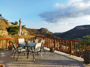 a patio with a table and chairs and an umbrella at VILLA CASTELLOS in Priniás +25 photos