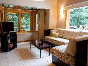 uma sala de estar com um sofá e uma mesa em ONA Apart Hotel and Spa em Villa La Angostura