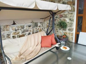 a table with a white couch with a pillow on it at VILLA CASTELLOS in Priniás