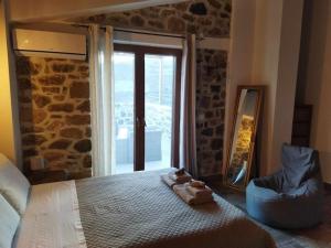 a bedroom with a bed with a mirror and a window at VILLA CASTELLOS in Priniás