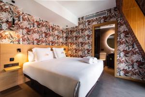 a bedroom with a large white bed with a floral wallpaper at Hotel Atari in Donostia-San Sebastián