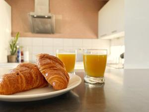 un plato con dos cruasanes y dos vasos de zumo de naranja en Le panoramique, en Saint-Herblain