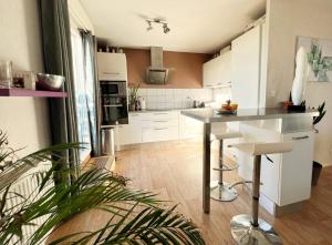 una cocina con armarios blancos y una mesa. en Le panoramique, en Saint-Herblain