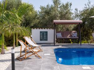 two chairs and a gazebo next to a pool at Cocoon Ocean Villa Luxury Escape in Peyia