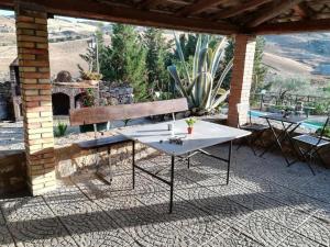 einen Tisch und eine Bank auf einer Terrasse mit Aussicht in der Unterkunft San Todero Country House in Centuripe