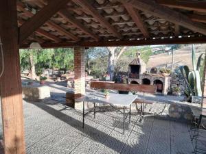 un patio al aire libre con mesa y chimenea en San Todero Country House, en Centuripe