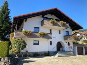 a white house with potted plants on the roof at Auszeit in Obermaiselstein