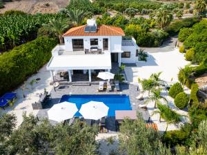 an aerial view of a house with a swimming pool and umbrellas at Cocoon Ocean Villa Luxury Escape in Peyia