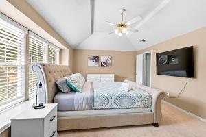 ein Schlafzimmer mit Bett und Flachbildfernseher in der Unterkunft 4BR, 2.5BA, sleep 11, close to highway and airport in Grapevine