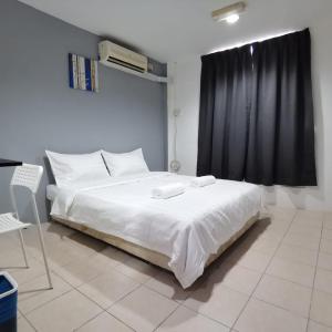 ein Schlafzimmer mit einem weißen Bett und einem schwarzen Vorhang in der Unterkunft Hotel Seroja in Labuan