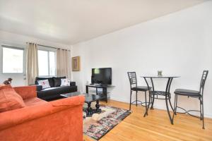 - un salon avec un canapé et une table avec des chaises dans l'établissement Coquette 3.5 pour 4 personnes, à Montréal