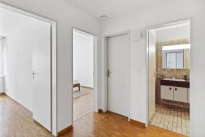 a white bathroom with a sink and a mirror at Beautiful Boutique Apartment DRAHTZUG14 in Zurich