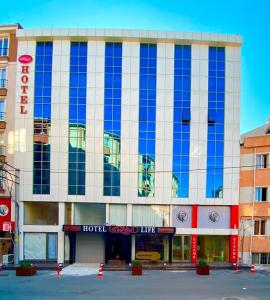 un edificio con ventanas azules en la parte delantera en Grand Life Hotel, en Çorlu