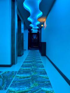 Grand Life Hotel في كورلو: ممر به أضواء زرقاء في مبنى