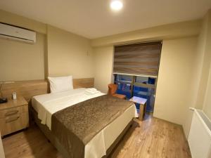 a bedroom with a large bed and a window at Grand Life Hotel in Çorlu