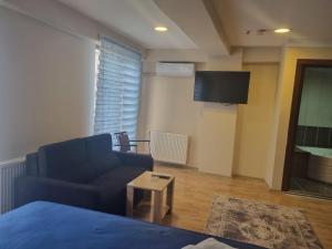 a living room with a couch and a tv at Grand Life Hotel in Corlu