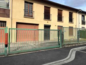 a green fence in front of a building at T1 in Toulouse